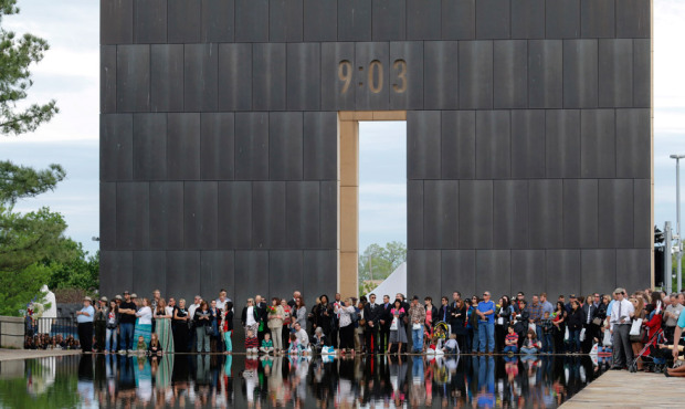 People gather at the end of the reflecting pool near the 9:03 Gate during a remembrance ceremony, S...