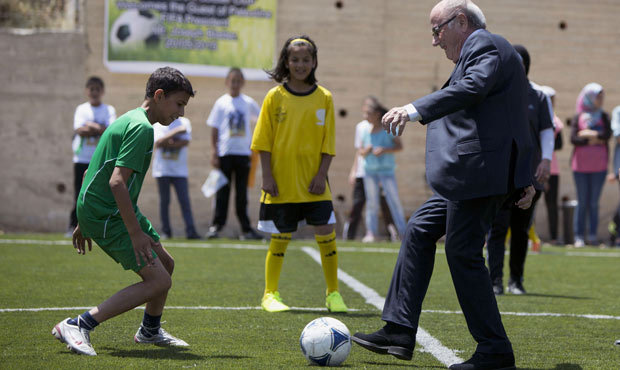 FIFA President Sepp Blatter kicks a ball during the inauguration of a football stadium in the villa...