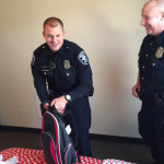 Seattle officers Ryan Gallagher and Jeremy Wade finish setting up a donated bed during a previous Beds for Kids drop off. (MyNorthwest)