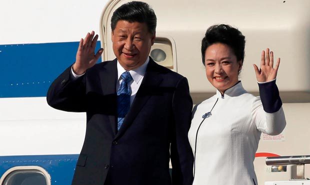 Chinese President Xi Jinping, left, and his wife Peng Liyuan wave upon arrival Tuesday, Sept. 22, 2...