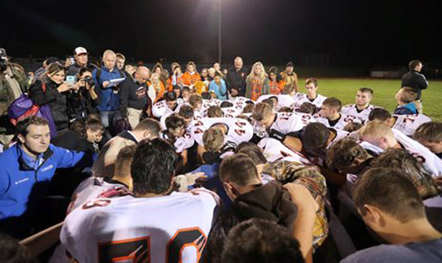 Bremerton football coach Joe Kennedy prays with players on the field. (AP)...