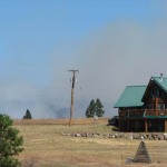 Smoke blooms off the horizon from a wildfire believed to have started accidentally by a construction crew in Central Washington, August 14, 2012. The fast-moving Taylor Bridge Fire has burned at least 26,000 acres since it broke out east of Cle Elum Monday, August 13, 2012.