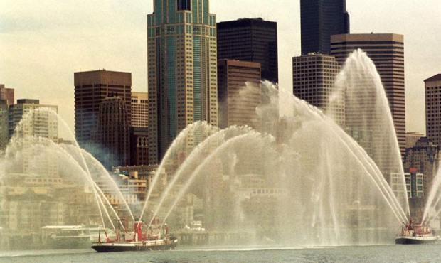 Seatttle fireboats Chief Seattle, left, and Alki, lead a parade of tug boats past the downtown skyl...