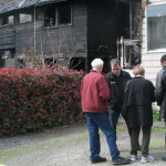 Owners and residents of a Queen Anne home burned in a fire set by an arsonist speak with an insurance agent Tuesday morning, April 2, 2013. (Josh Kerns/MyNorthwest.com)