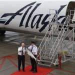 Alaska Airlines first officer Peter Michels carries a 40-pound Copper River salmon off the plane as Capt. Jeff Meyer looks on as the first shipment of the valuable fish arrives in Seattle from Cordova, Alaska, Friday, May 17, 2013. The arrival of the salmon, which is prized for it's taste and color, is a rite of spring in Seattle, and the fish bring top dollar in restaurants and fish markets. (AP Photo/Ted S. Warren)
