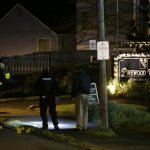 Police officers stand near evidence markers at the scene of an overnight shooting that left five people dead, Monday, April 22, 2013, at the Pinewood Village apartment complex in Federal Way, Wash. (AP Photo/Ted S. Warren)