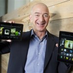 In this image distributed on Tuesday, Sept. 24, 2013, Amazon.com Founder and CEO Jeff Bezos introduces the all-new Kindle Fire HDX 8.9'', right, and Kindle Fire HDX 7'' tablet in Seattle."