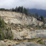 A now-barren hillside overlooks the valley below at the scene of a deadly mudslide, Wednesday, April 2, 2014, in Oso, Wash. Officials have so far confirmed the deaths of 29 people, although only 22 have been officially identified in information released Wednesday morning by the Snohomish County medical examiner's office. (AP Photo/Elaine Thompson)