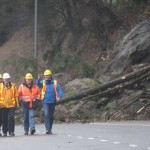 Washington Gov. Jay Inslee, right, is briefed by department of transportation officials as they survey the scene of a mudslide obstructing the northbound lane of I-5 near Woodland on Dec. 10. Boulders, trees and dirt slid onto the highway in the day before following heavy rains.            