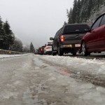 Vehicles along eastbound Interstate 90 heading up Snoqualmie Pass are stopped in snow and slush during a road closure. 