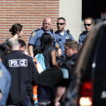Young people are escorted past police officers following a shooting on the campus of Seattle Pacific University Thursday, June 5, 2014, in Seattle. Seattle police now say there are four victims in a shooting and say one suspect is in custody. Police say one man and one woman have life-threatening injuries while another man and another woman are reported in stable condition.(AP Photo/Elaine Thompson)