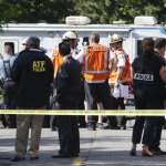 Authorities gather at the scene of a shooting Thursday, June 5, 2014 at Seattle Pacific University in Seattle. A lone gunman armed with a shotgun opened fire Thursday in a building at the small Seattle university, killing one person before he was subdued by a student as he tried to reload, police said. Police say the student building monitor disarmed the gunman and several other students held him until police arrived at the Otto Miller building. (AP Photo/Ted S. Warren)