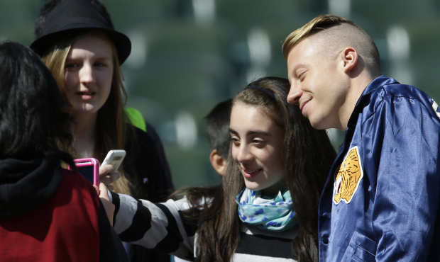 Rapper Macklemore, right, joins in a “selfie” photo Thursday, April 10, 2014 with one o...