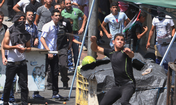 Palestinian protesters hurl stones at Israeli soldiers during clashes, following a protest against ...