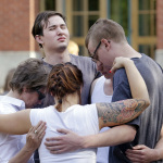 Students and faculty pray together following a shooting on the campus of Seattle Pacific University Thursday, June 5, 2014, in Seattle. Seattle police now say there are four victims in a shooting and say one suspect is in custody. Police say one man and one woman have life-threatening injuries while another man and another woman are reported in stable condition.(AP Photo/Elaine Thompson)