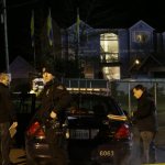Police officers stand by their car at the scene of an overnight shooting that left five people dead, Monday, April 22, 2013, at the Pinewood Village apartment complex in Federal Way, Wash. (AP Photo/Ted S. Warren)