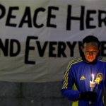 Lizzie Lee, 56, of Lynwood, Wash., who was participating in her first Boston Marathon and 11th overall, holds a candle and a flower at Boston Common during a vigil for the victims of the Boston Marathon explosions, Tuesday, April 16, 2013. (AP Photo/Julio Cortez)
