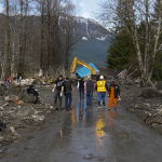 In Oso, Wash., Monday, March 24, 2014,Washington Gov. Jay Inslee and a small entourage walk eastward on a cleared swath of SR 530, toward the first house that lies in a heap across the highway. (AP Photo /The Herald, Dan Bates)