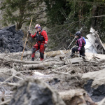 Searchers look through debris from a deadly mudslide Tuesday, March 25, 2014, in Oso, Wash. (AP Photo/Elaine Thompson)