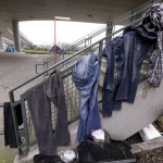 Clothing hangs from the handrail of stairs near the baseball stadium at a small homeless encampment in Seattle on Tuesday, Feb. 9, 2016. Mayor Ed Murray has committed millions of dollars to expand shelter beds and social services. (AP Photo/Elaine Thompson)