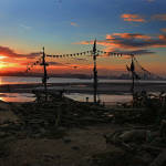 The sun rises behind a beach installation made of driftwood of the Black Pearl pirate ship on New Brighton beach, Liverpool, northwest England on Thursday. The installation was created by artist Frank Lund and Major Mace. (Peter Byrne/PA via AP) 