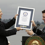 Washington Gov. Jay Inslee, left, accepts a certificate from Guinness World Record Judge Michael Empric, right, recognizing the new State Route 520 floating bridge across Lake Washington as the longest floating bridge in the world, Saturday, April 2, 2016, during a grand opening ribbon-cutting ceremony in Seattle. The bridge will open to traffic later in the month. (AP Photo/Ted S. Warren)