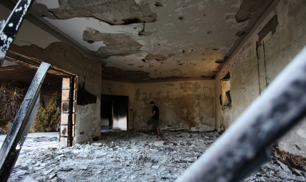 This Sept. 13, 2012 photo shows a man walking in the rubble of the damaged U.S. consulate, after an...