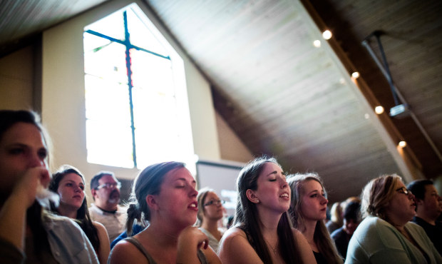 Seattle Pacific University students and faculty pray together at First Free Methodist Church follow...
