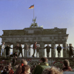 FILE - In this Nov. 10, 1989 file photo Berliners sing and dance on top of The Berlin Wall to celebrate the opening of East-West German borders. Thousands of East German citizens moved into the West after East German authorities opened all border crossing points to the West. In the background is the Brandenburg Gate. (AP Photo/Thomas Kienzle)