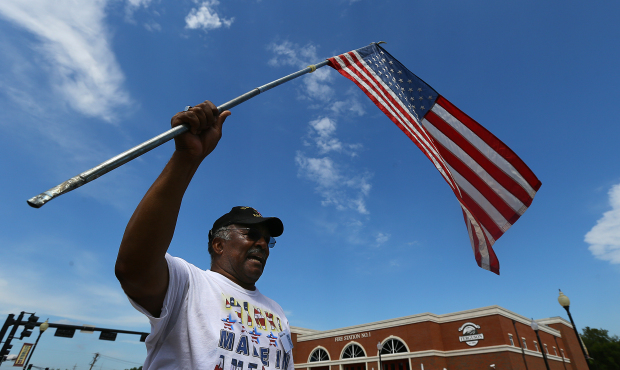 Protester Walter Rice, 75, a life long Ferguson resident and Vietnam veteran waves an American flag...