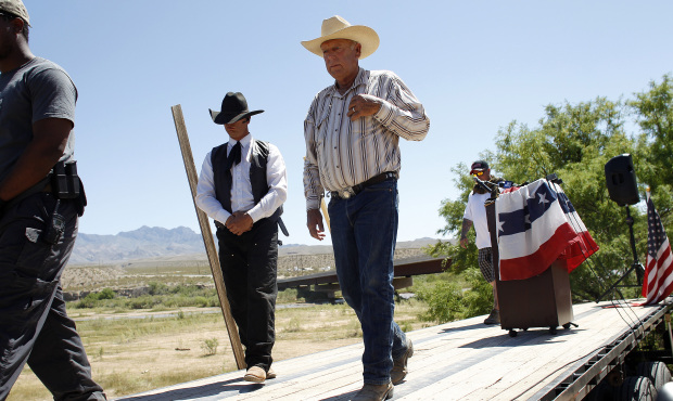 Rancher Cliven Bundy, center, walks off stage after speaking at a news conference near Bunkerville,...