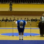 Dennis Rodman bows to North Korean leader Kim Jong Un, seated above in the stands, before an exhibition basketball game with U.S. and North Korean players at an indoor stadium in Pyongyang, North Korea on Wednesday, Jan. 8, 2014. (AP Photo/Kim Kwang Hyon)