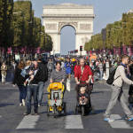 People walk on the Champs Elysees during the "day without cars", in Paris, France on Sept. 27. Pretty but noisy Paris, its gracious Old World buildings blackened by exhaust fumes, is going car-less for a day. Paris Mayor Anne Hidalgo presided over Sunday's "day without cars," two months before the city hosts the global summit on climate change. (AP Photo/Thibault Camus)